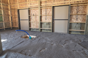Crusher fines installed underneath future horse stall mats with underground horse waterer plumbing prep inside a custom Castle Rock Colorado horse barn before concrete installation.