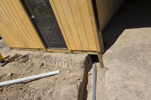 Underground electrical conduit and utility trenching outside a custom horse barn tack room in Castle Rock Colorado before concrete and finish grading.