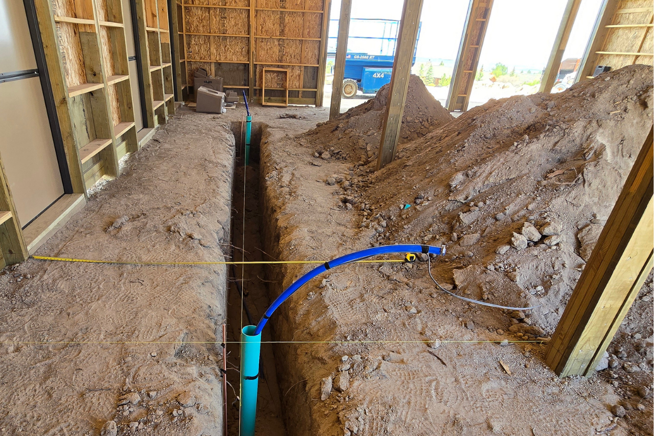 Custom horse barn trenching in Castle Rock Colorado with underground plumbing, electrical rough-ins, and automatic horse waterer prep before concrete installation.